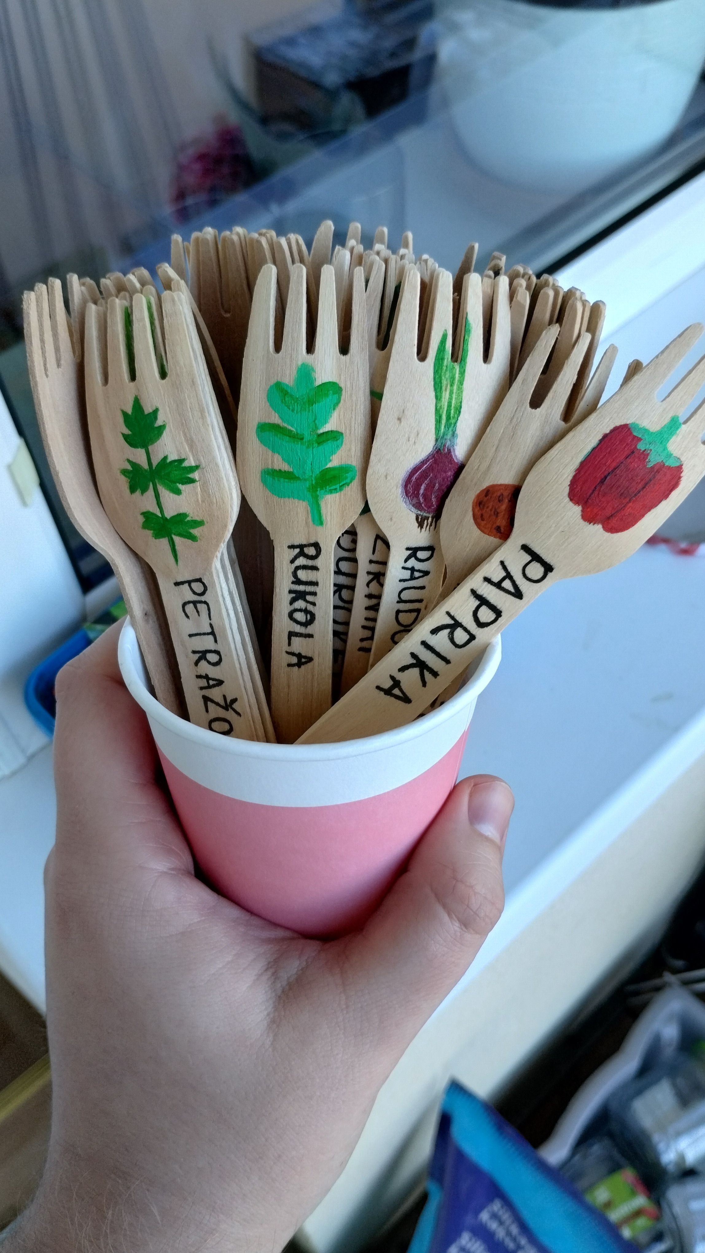 A cup of sporks with vegetable names on them