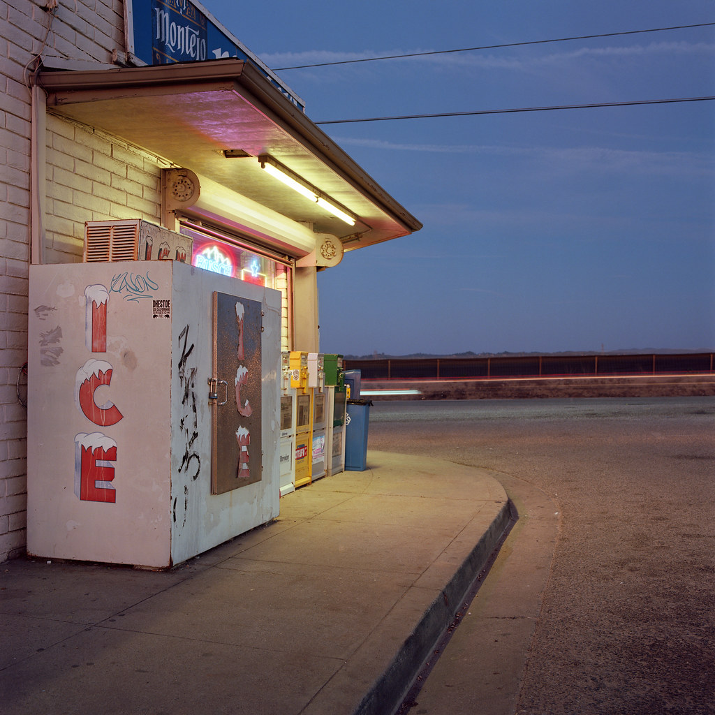 An ice machine by a convenience store