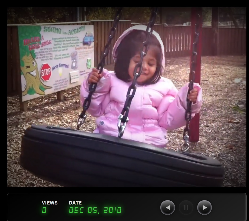 small smiling child on tire swing