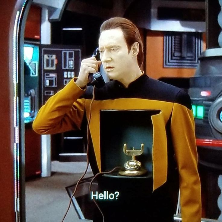 confused Data from Star Trek answering an antique phone sitting in a strange cabinet in his belly