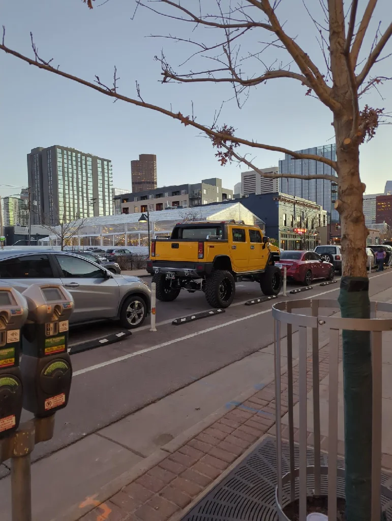 Un Hummer jaune ridiculement surélevé dans les 
rues ensoleillés de la banlieue de Denver, devant un restaurant mexicain giga bon