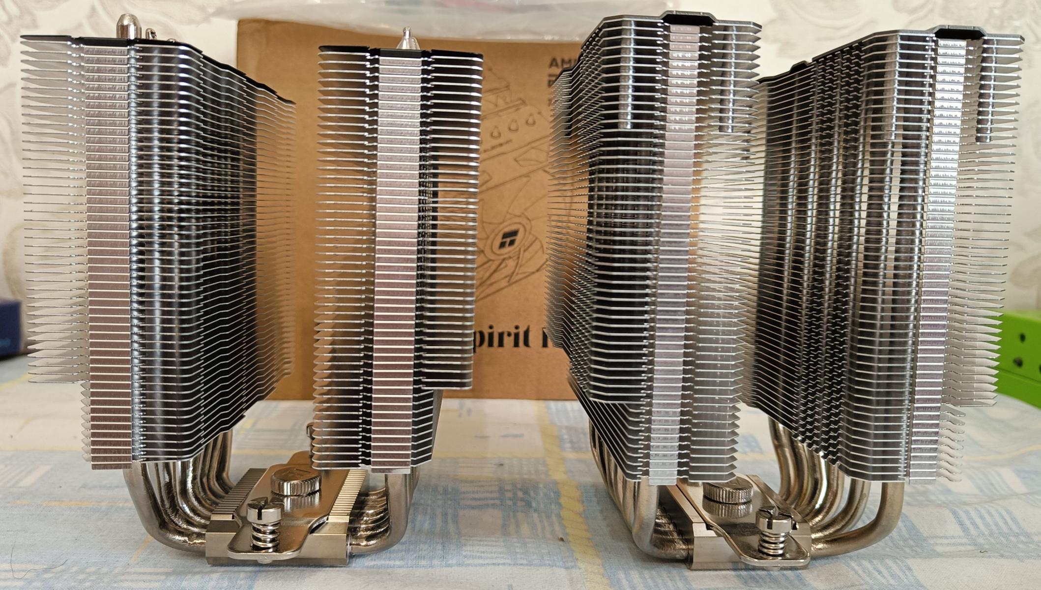 Image shows two dual-tower CPU coolers, the Thermalright Phantom Spirit 120 SE on the left and the Phantom Spirit 120 on the right. The overall design is similar, but the cooler on the left appears to be shorter than the one on the right. The company reports that they are 154mm tall and 157mm tall, respectively.