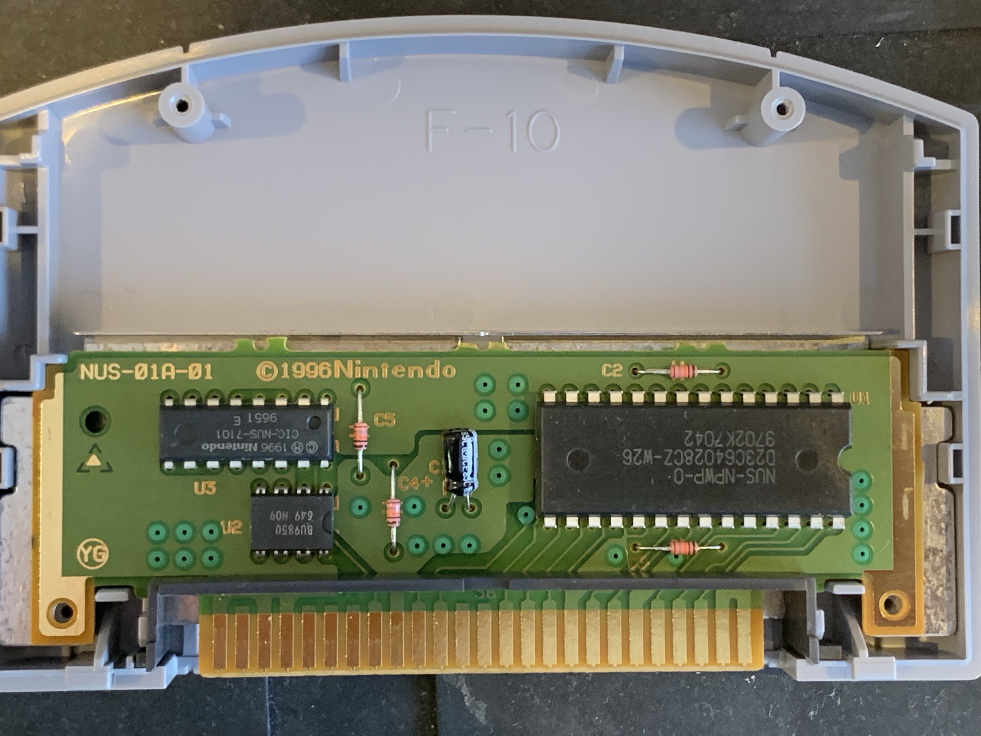 The opened cartridge exposing a very small PCB with the usual CIC copy protection chip. A small 8 pin DIP EEPROM and the main DIP28 ROM chip. 